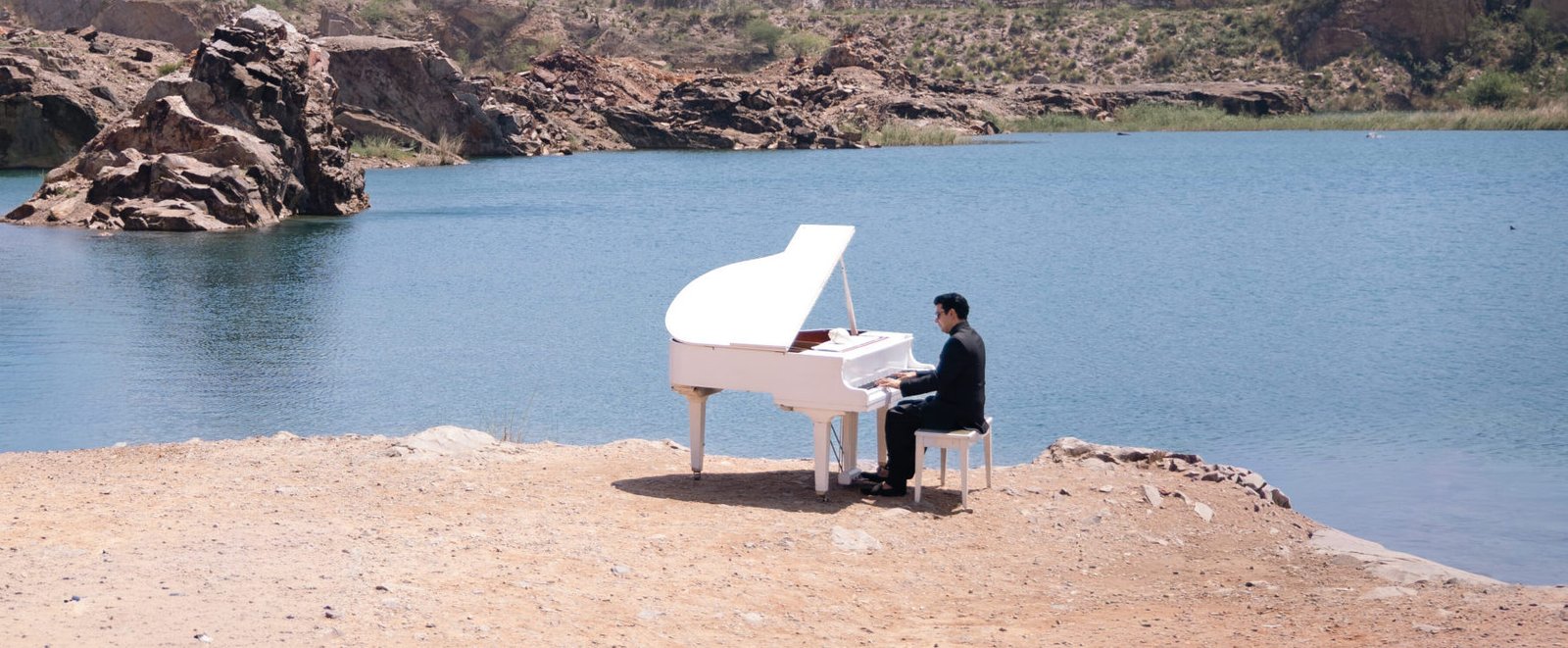 The ABC's of Music 1 Dr Aman Bathla performing near a lake on his piano